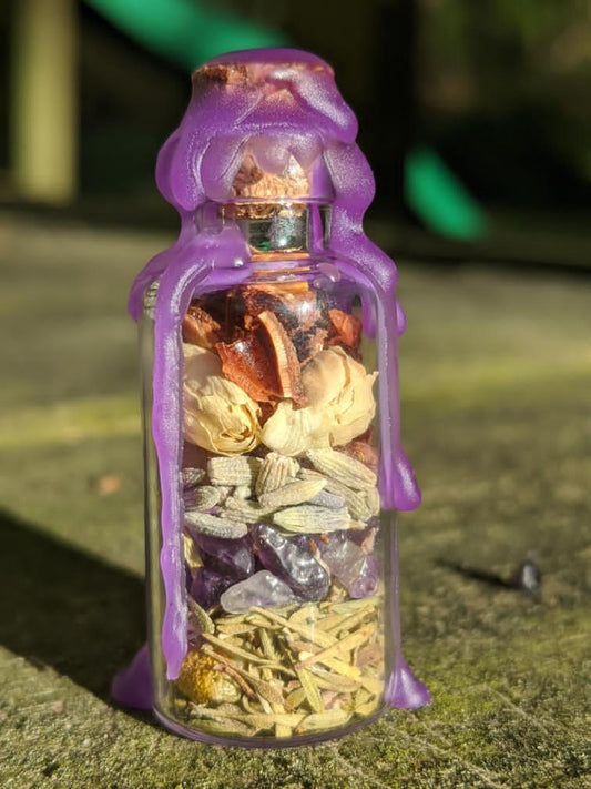 A glass bottle filled with herbs, crystals, and powders sealed with purple wax.